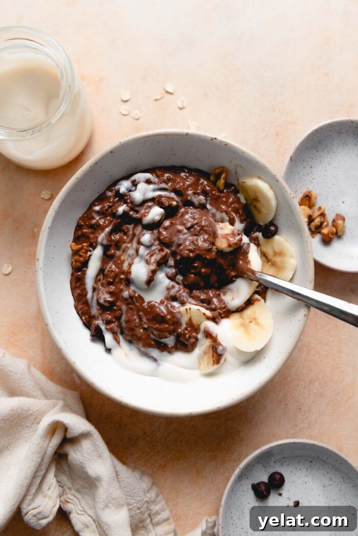 Brownie Batter Overnight Protein Oats Recipe 6 Bowl of chocolate oatmeal topped with sliced banana, nuts and yogurt.