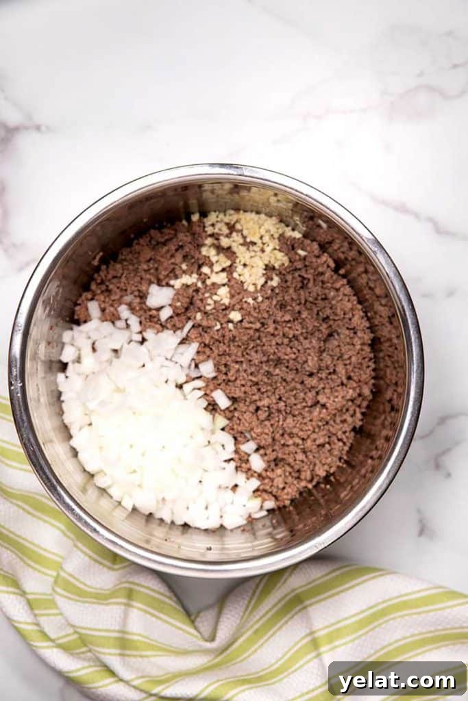 cooked ground beef with chopped onions and minced garlic in an instant pot