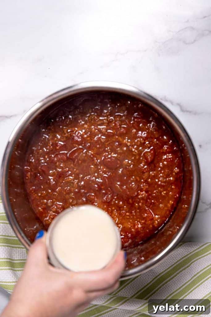 pouring masa harina and water over the chili