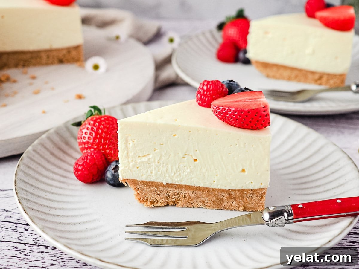 Philadelphia No-Bake Cheesecake Recipe — Creamy, Refrigerator Cheesecake 2 Slice of cheesecake on a plate with fresh berries and rest of cake and another slice of cheesecake in the background.