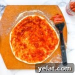 San Marzano sauce brushed onto a pizza crust.