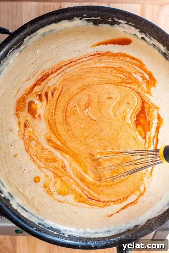 Skillet Buffalo Chicken Macaroni and Cheese Recipe 15 Whisking buffalo sauce into a creamy cheese sauce in a cast iron skillet.