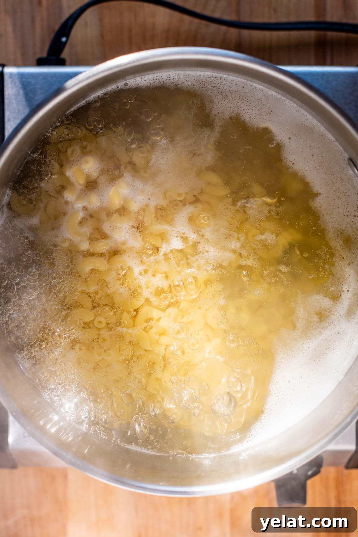Skillet Buffalo Chicken Macaroni and Cheese Recipe 7 Overhead view of elbow macaroni noodles boiling in a large pot of water.