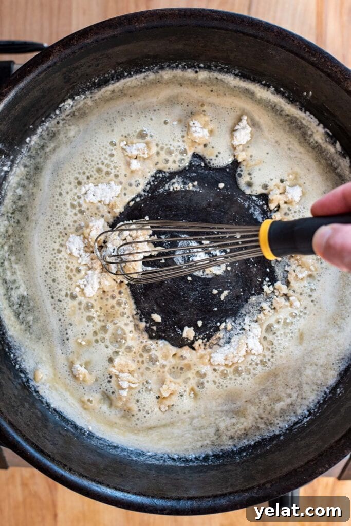 Skillet Buffalo Chicken Macaroni and Cheese Recipe 9 Whisking flour into melted butter in a cast iron skillet.