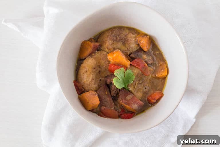 plantain curry with duck and sweet potatoes in a large white bowl
