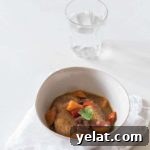 overhead view of plantain curry in white bowl on a white towel