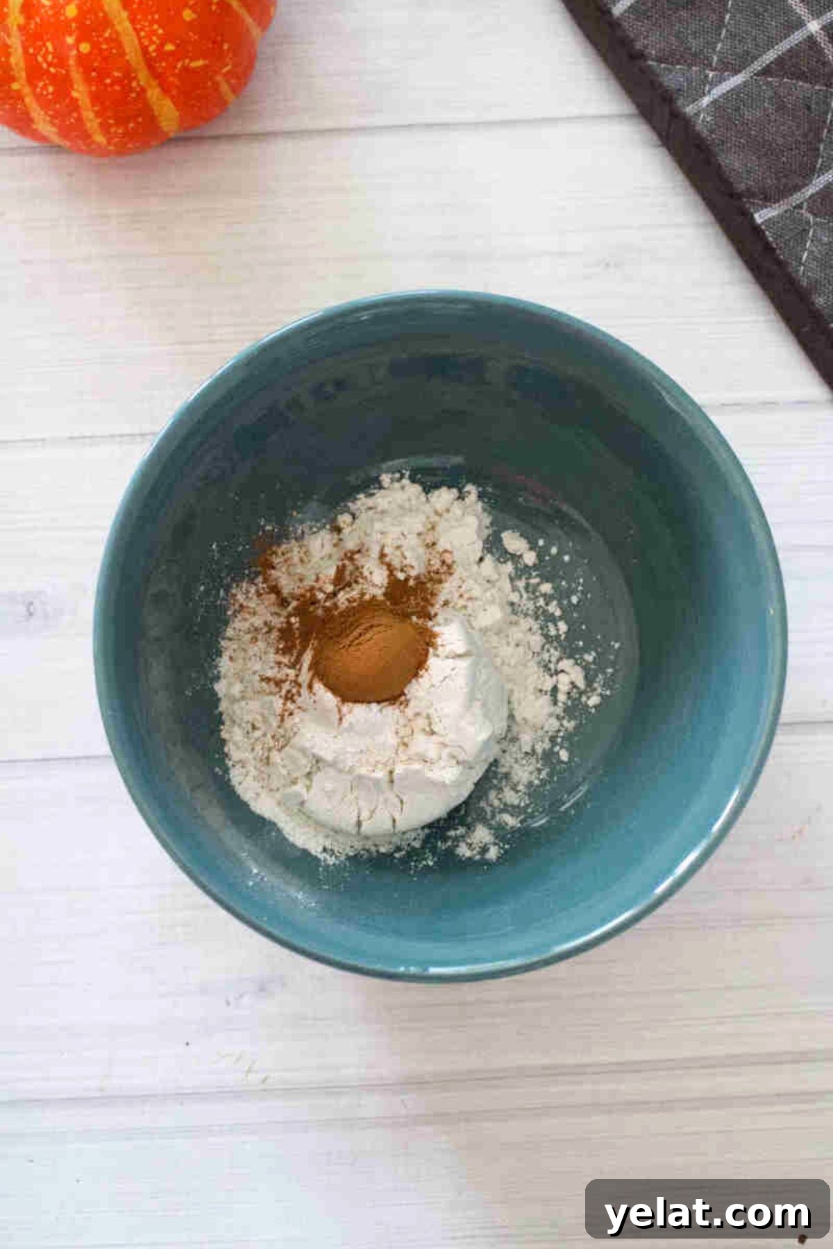 Blue bowl with flour and cinnamon in it.