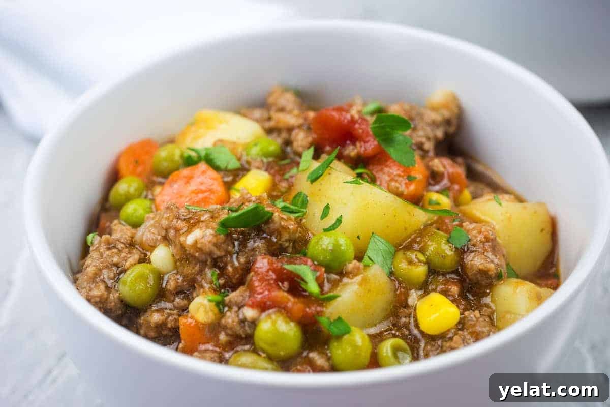 A white bowl filled with easy Hamburger stew garnished with parsley.