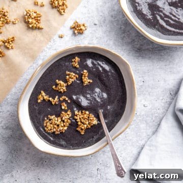 Blueberry spinach smoothie in bowl with maple buckwheat clusters on top