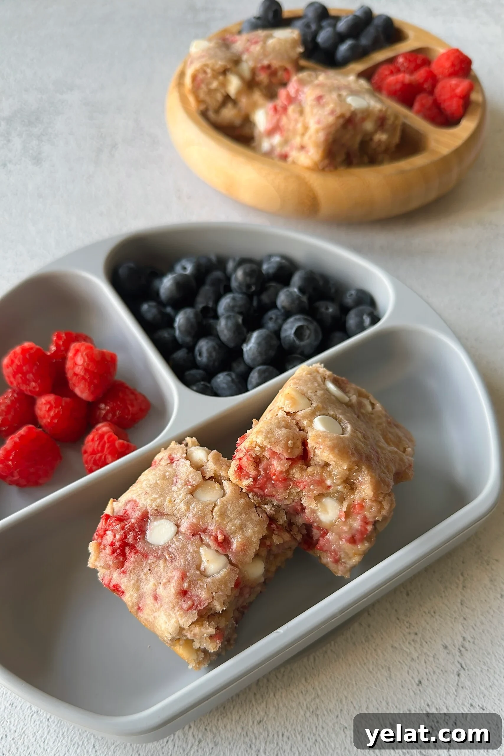 Raspberry White Chocolate Blondies Recipe — Chewy Berry Bars 2 Raspberry white chocolate blondies served with berries.
