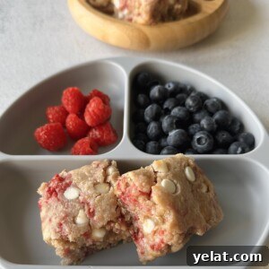 Raspberry White Chocolate Blondies Recipe — Chewy Berry Bars 12 Raspberry white chocolate blondies served with berries.