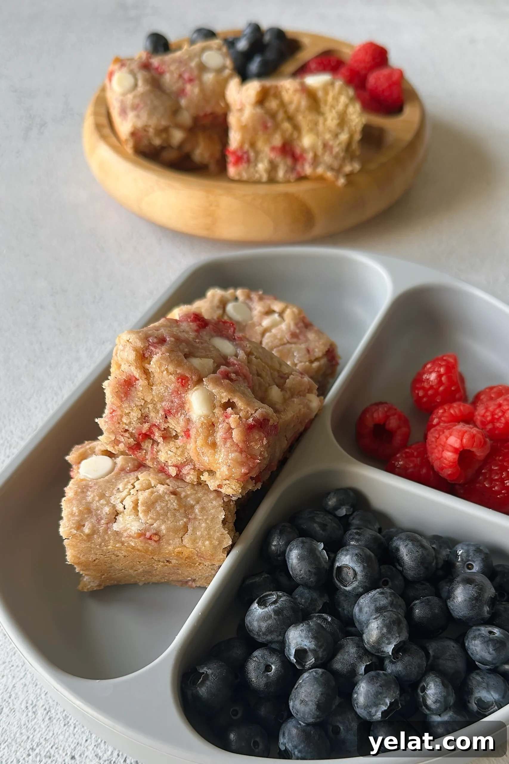 Raspberry White Chocolate Blondies Recipe — Chewy Berry Bars 7 Raspberry white chocolate blondies served with berries.