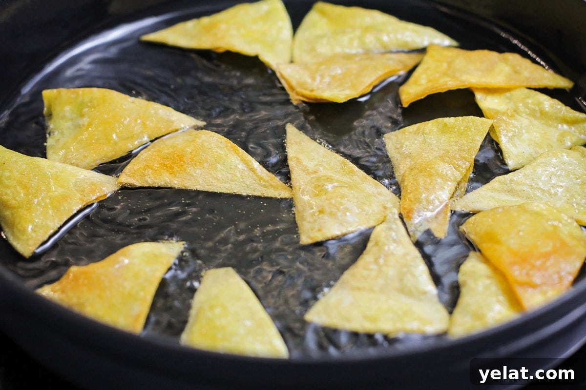 Add a little spice to your breakfast with this authentic chilaquiles recipe - a Mexican classic that's on the table in only 20 minutes! Frying tortilla triangles in a pan of oil.