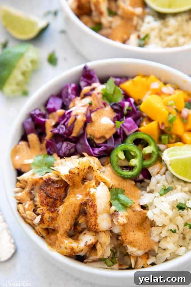 taco bowl side view of a healthy fish taco bowl with mango salsa and cilantro lime cauliflower rice
