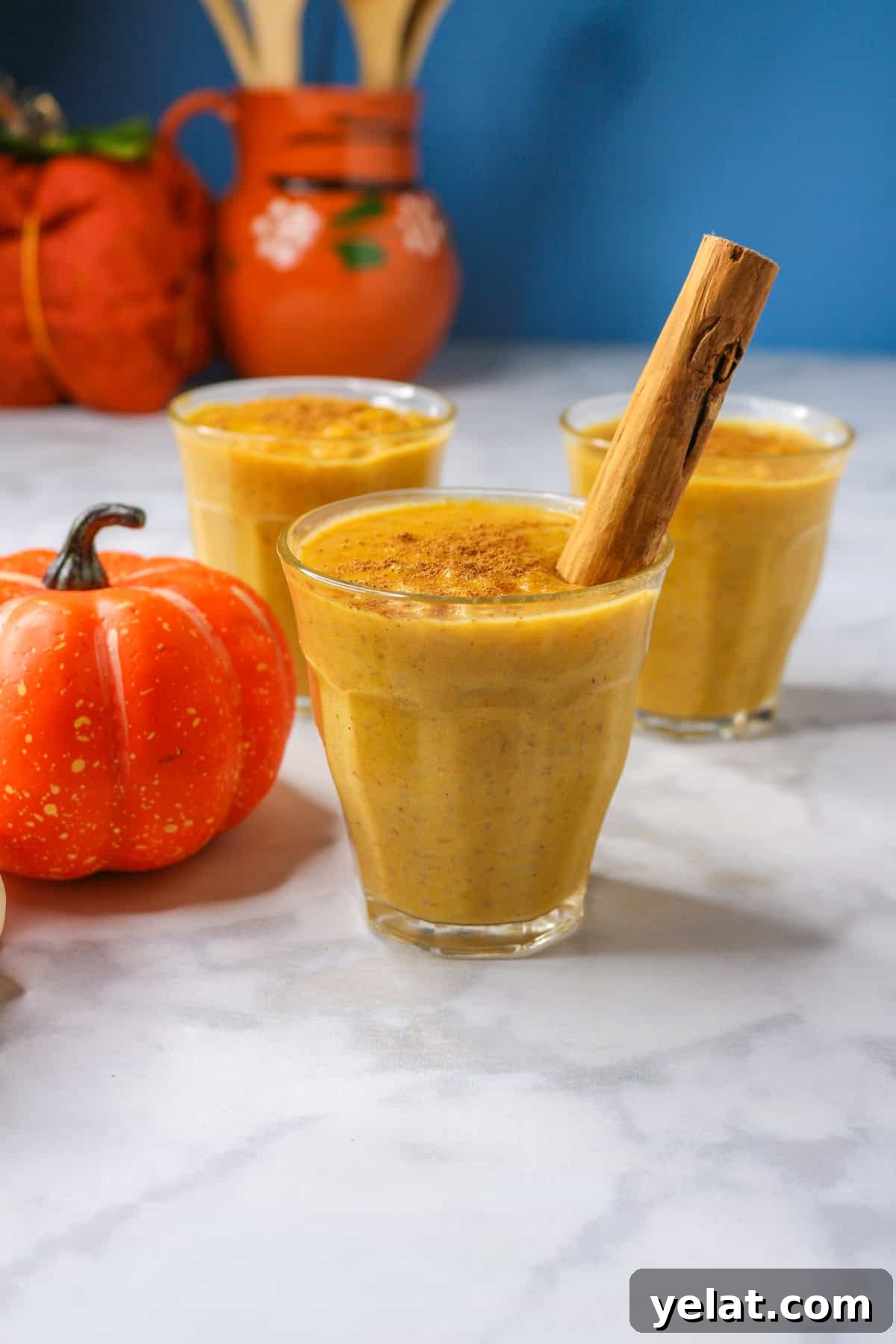 Pumpkin arroz con leche in a glass cup garnished with a cinnamon stick