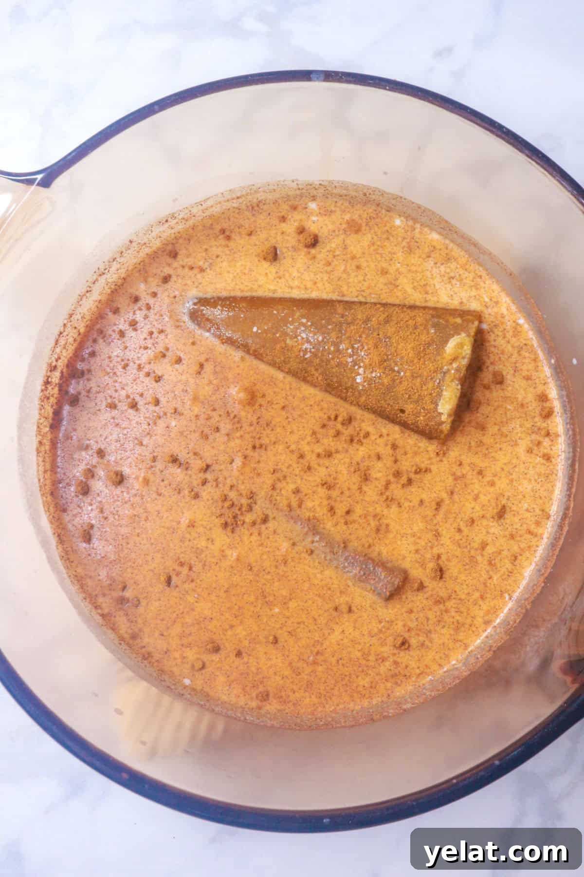 Milk, cinnamon stick, pumpkin spice and rice in a pot