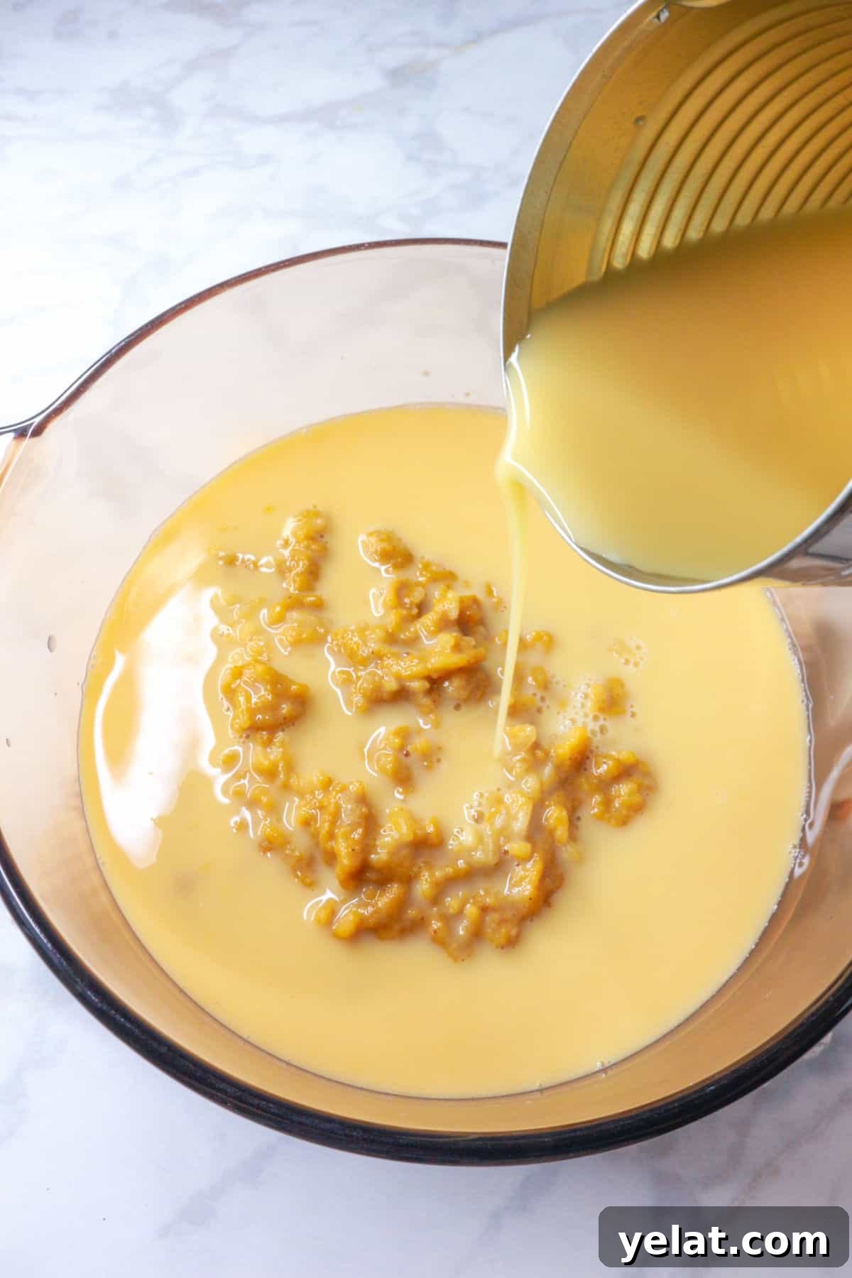 Pouring evaporated milk from a can to a pot with arroz con leche