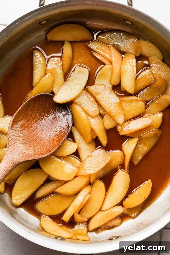 Classic Apple Dutch Baby Pancake Recipe — Fluffy Skillet Treat 8 spiced apples in a pan