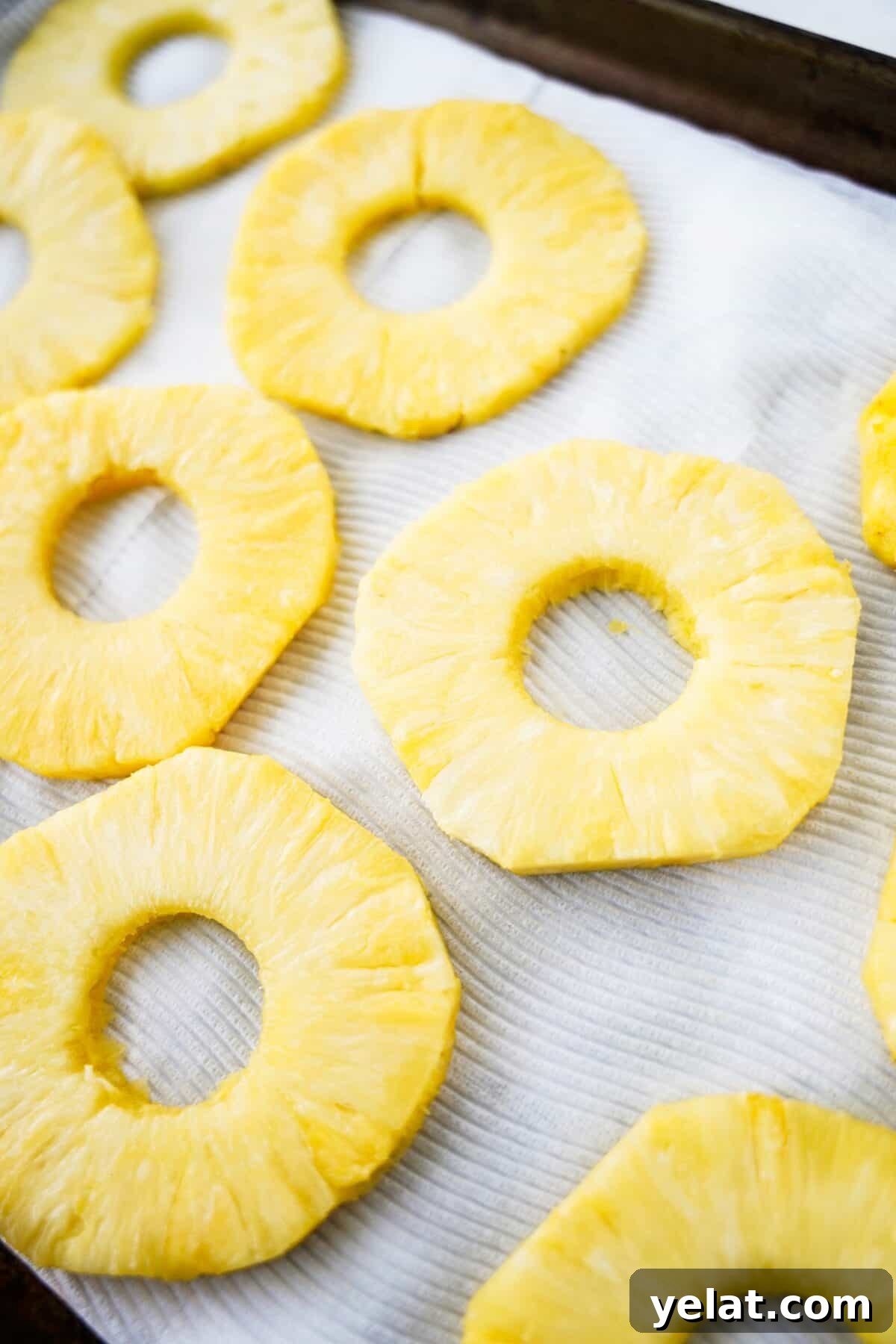 Spicy Pineapple Tart Recipe: Sweet and Tangy Baked Cookies 6 overhead shot of pineapples on baking sheet with paper towels to dry them out
