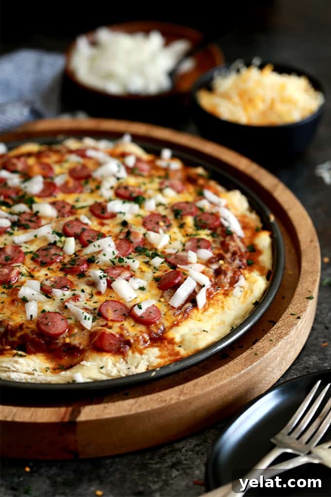 Sliced Chili Cheese Dog Pizza with bright garnishes. Sliced Chili Cheese Dog Pizza with bright garnishes.