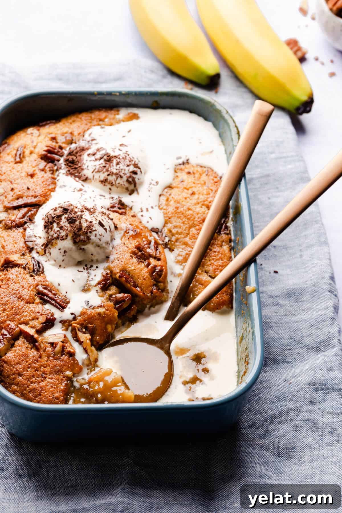 Self-Saucing Banana Pudding Recipe with Gooey Caramel Sauce 2 side angle of banana pudding topped with melting ice cream and revealing the sauce underneath