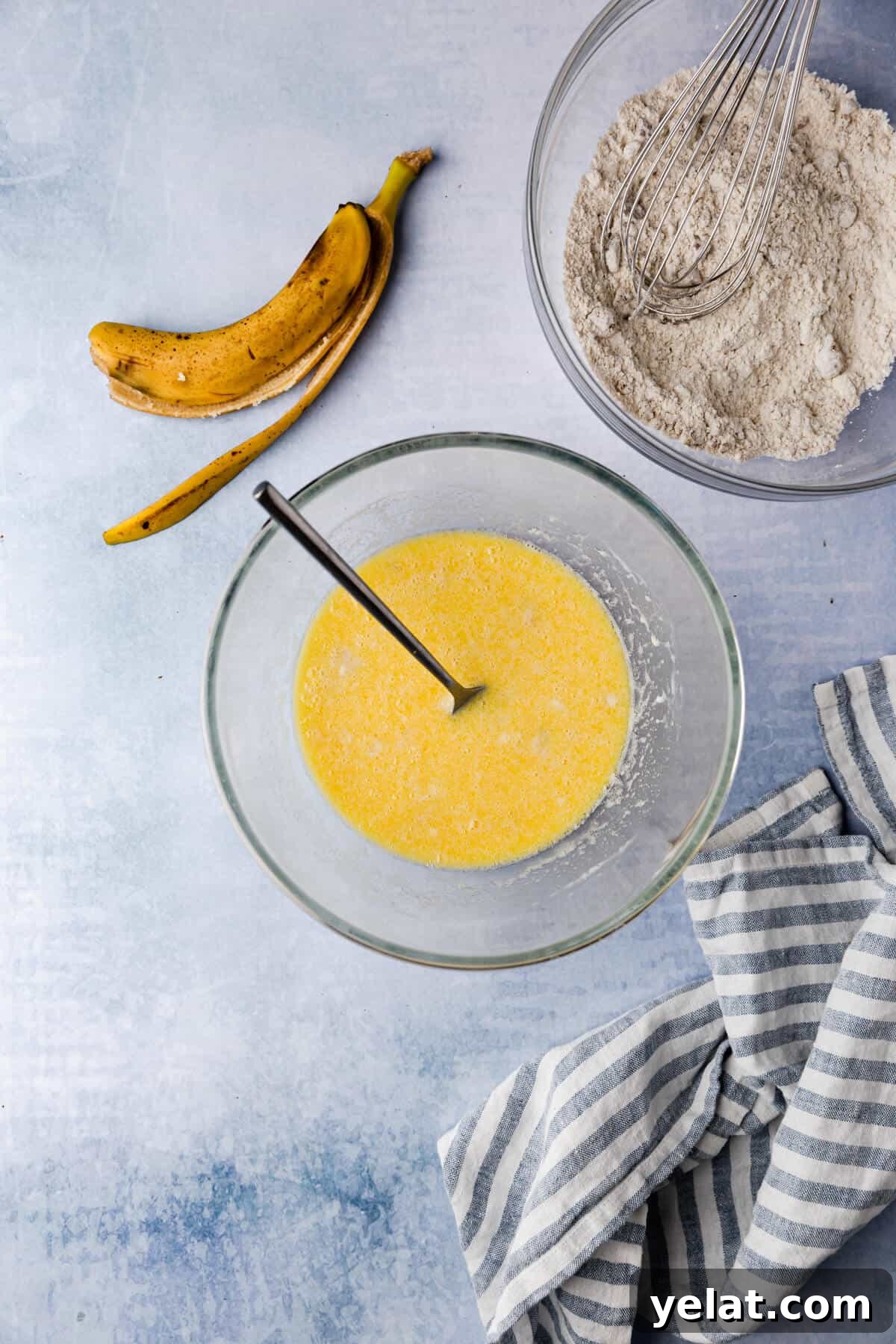 Self-Saucing Banana Pudding Recipe with Gooey Caramel Sauce 5 overhead image of a glass bowls with wet and dry ingredients and banana peel on side