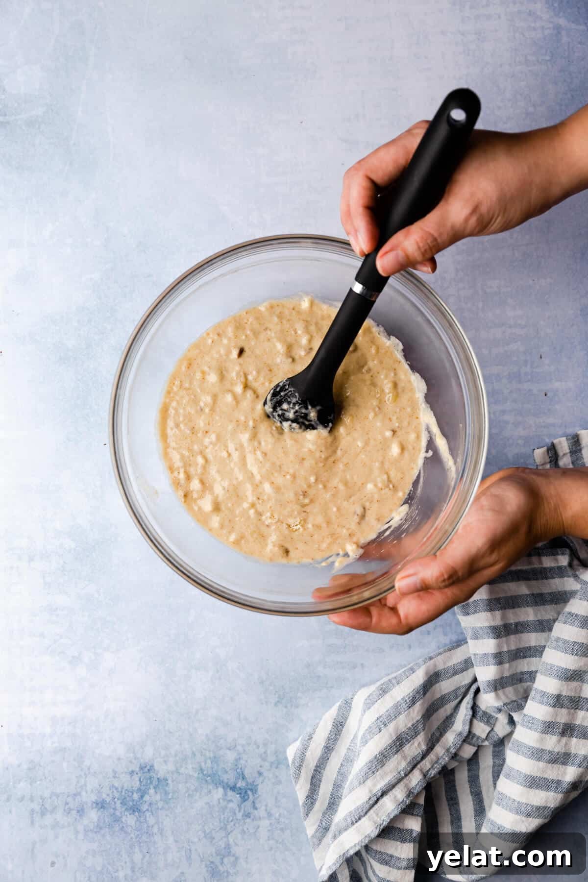 Self-Saucing Banana Pudding Recipe with Gooey Caramel Sauce 6 top view of a person mixing the batter in a bowl with spatula