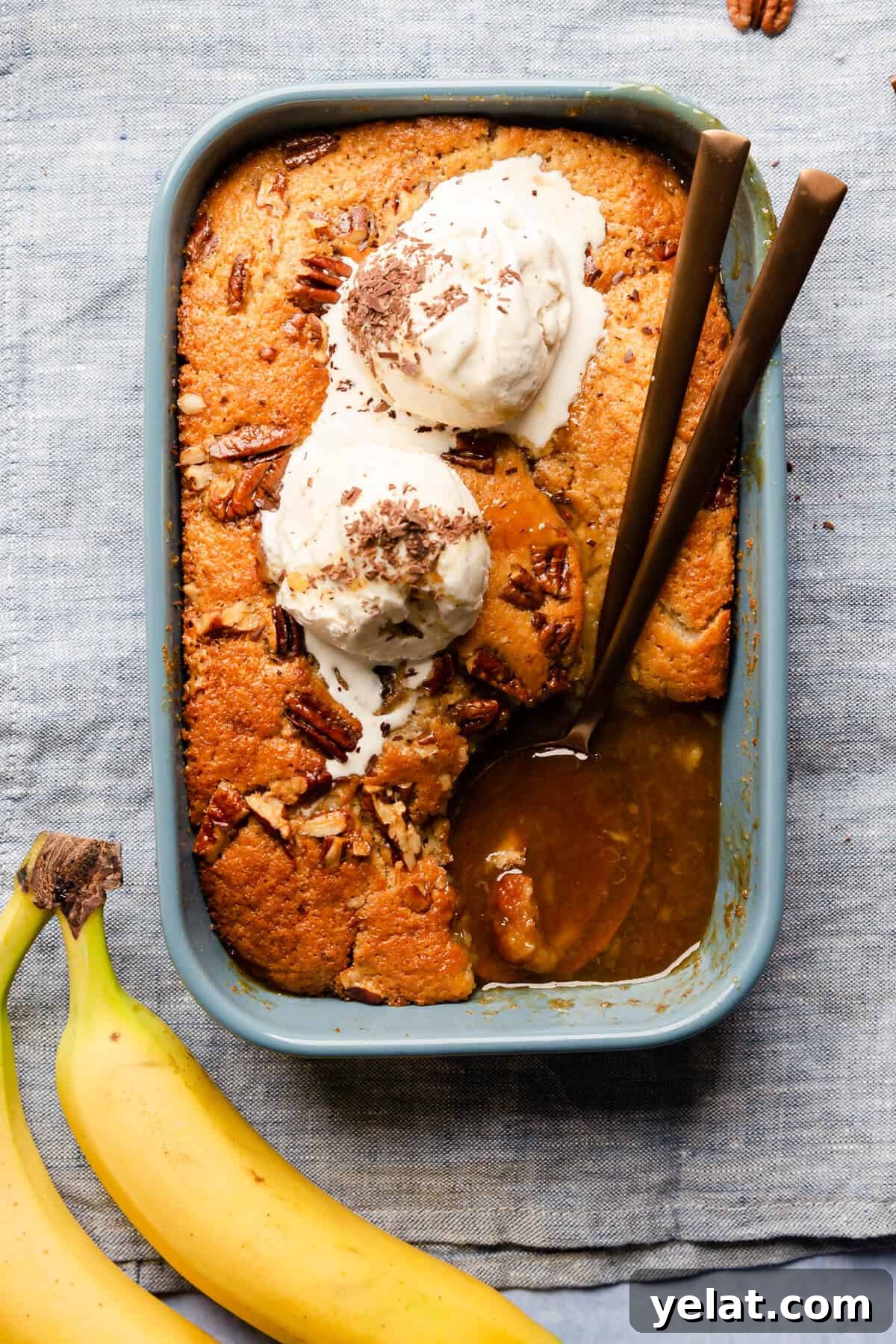 Self-Saucing Banana Pudding Recipe with Gooey Caramel Sauce 10 top view at baking dish with self saucing banana pudding topped with ice cream