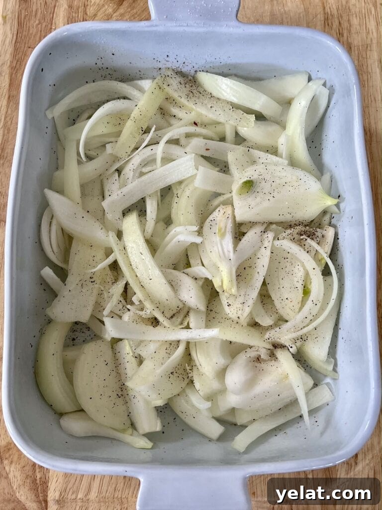 Slow-Roasted Mediterranean Lamb Shoulder Recipe 10 Sliced yellow onions on bottom of oil-rubbed baking dish.