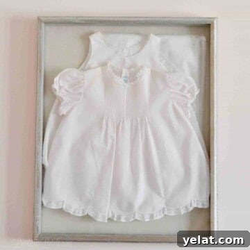 pink baby dress in a shadow box on a wall.
