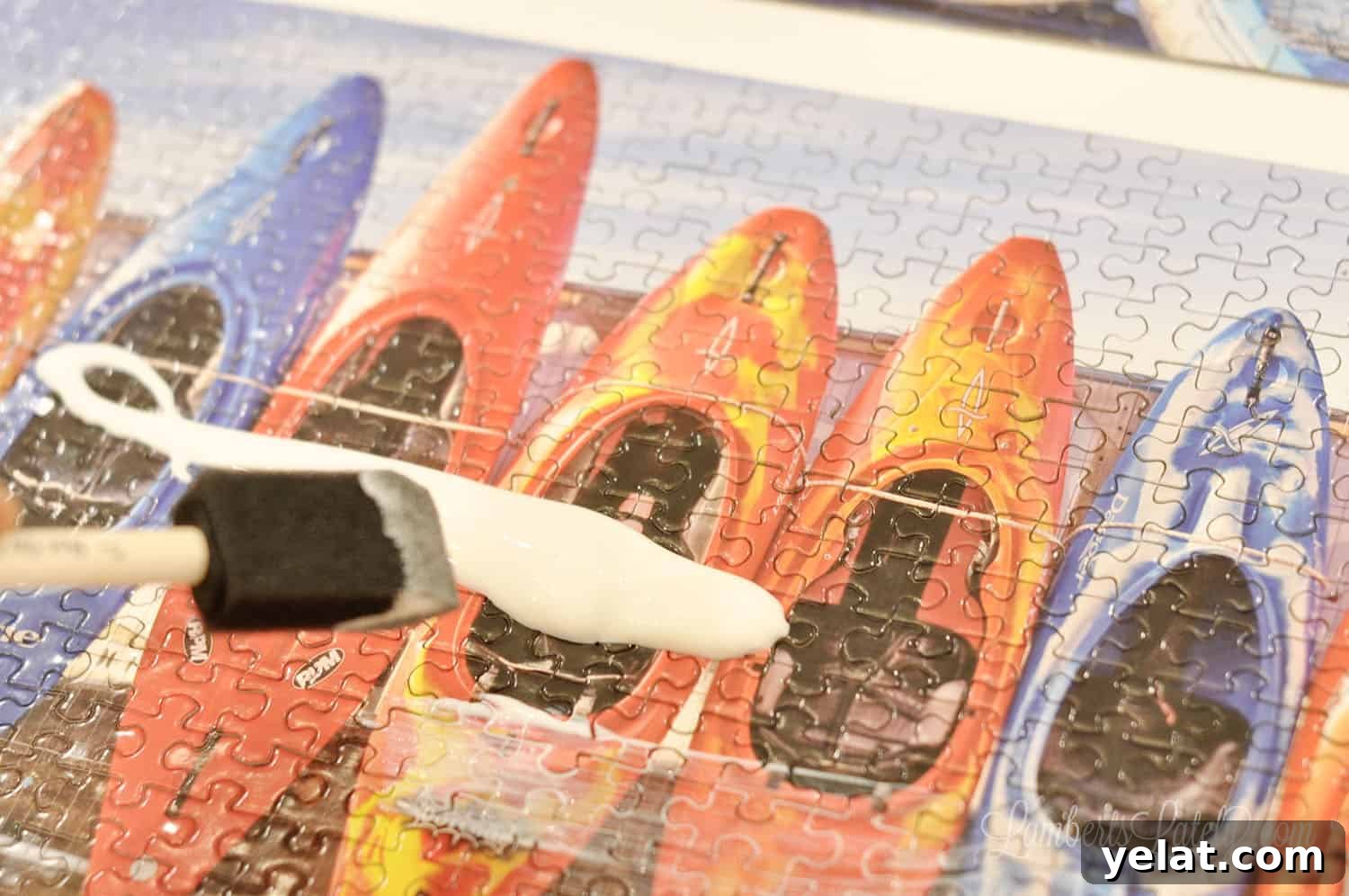 How to Glue and Hang a Puzzle Without a Frame 6 mod podge poured on a puzzle, spreading with a sponge brush.