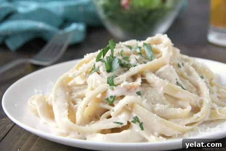 Cheesy Instant Pot Chicken Alfredo on plate with Parmesan and parsley