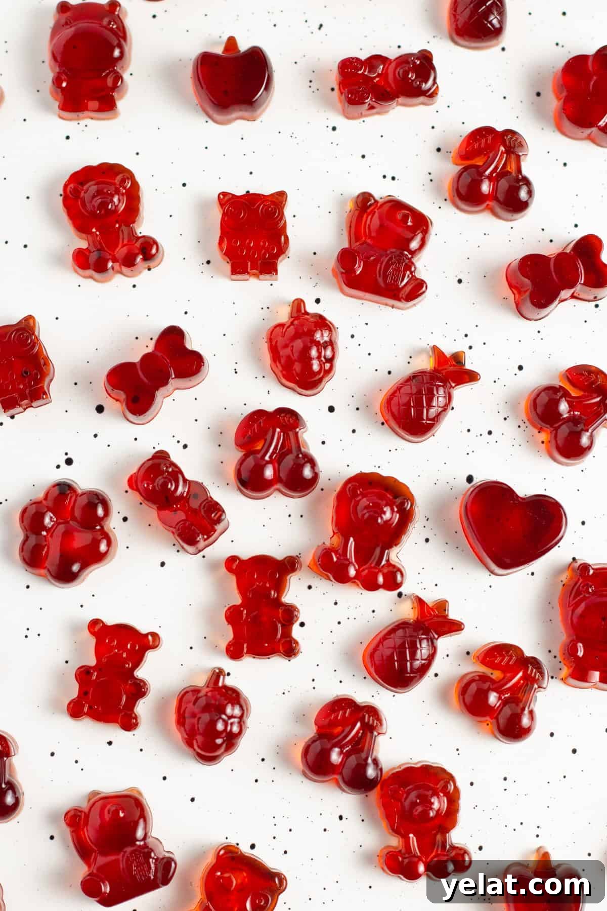 Tart Cherry Gummies for Sleep, Recovery & Joint Support 4 Overhead view of bright red tart cherry gummies spread out on a white countertop.