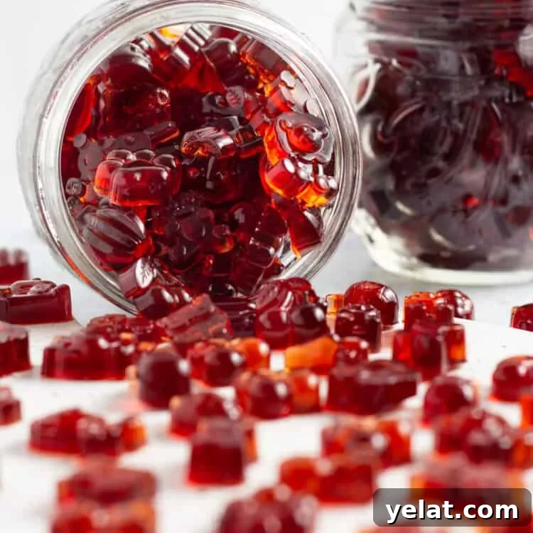 Tart Cherry Gummies for Sleep, Recovery & Joint Support 6 Side view of a jar of tart cherry gummies, with cherry gummies spilling out onto a white countertop.