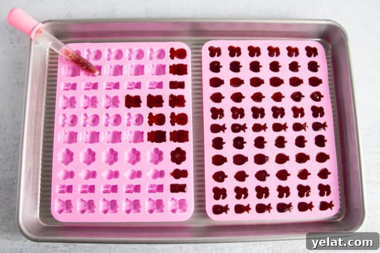 Tart Cherry Gummies for Sleep, Recovery & Joint Support 9 Overhead view of two gummy molds partially filled with tart cherry gummy liquid, with a dropper of liquid on one mold.