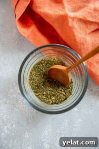 15 Homemade Seasoning Recipes to Transform Your Cooking 9 small glass jar of seasonings with wooden spoon stirring