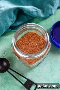 15 Homemade Seasoning Recipes to Transform Your Cooking 10 Glass jar with creole seasoning next to black tablespoon