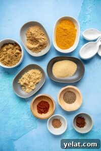 15 Homemade Seasoning Recipes to Transform Your Cooking 14 tiny bowls filled with spices to make curry seasoning on a blue backdrop