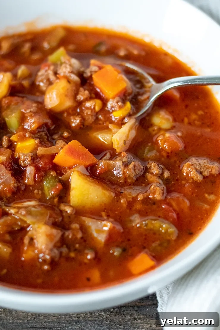 Hearty Vegetable Beef Soup Recipe with Savory Homemade Broth 8 Close up of soup in bowl with spoon.