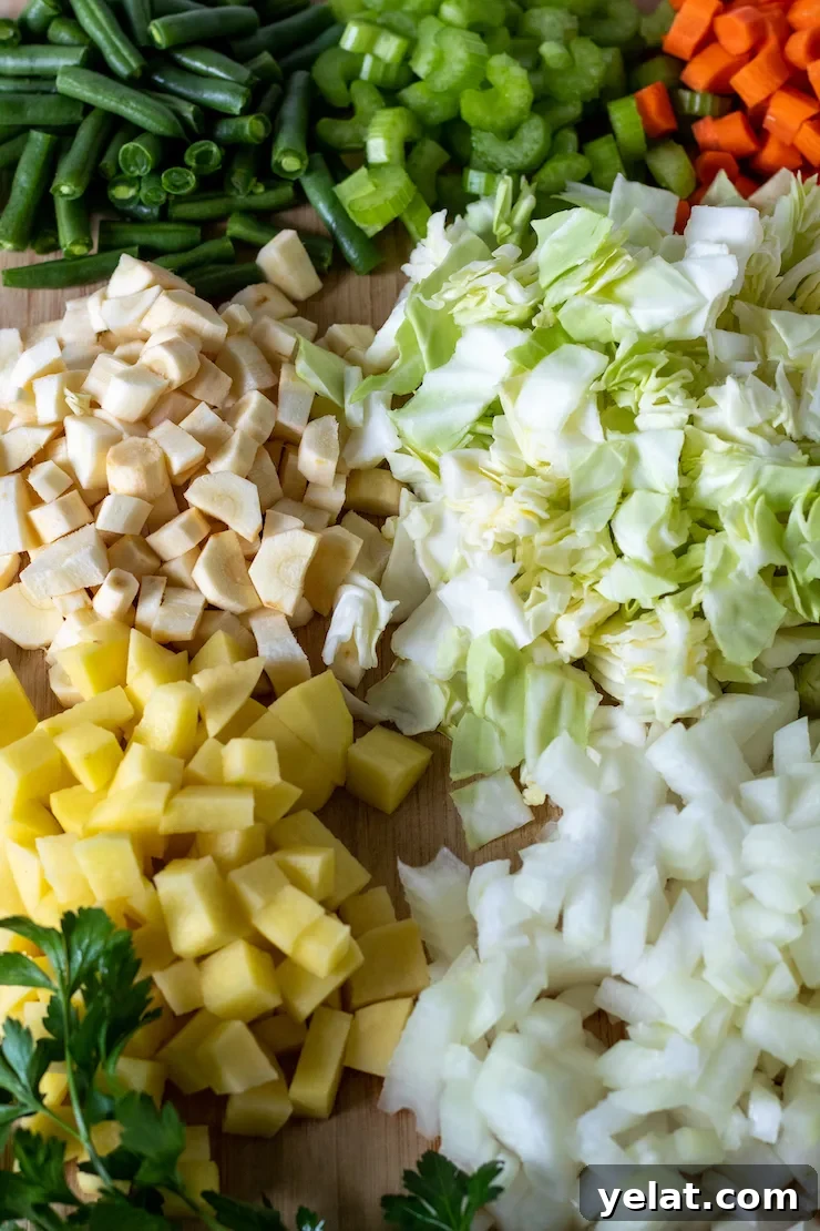 Hearty Vegetable Beef Soup Recipe with Savory Homemade Broth 4 Cutting board filled with prepped and chopped vegetables.
