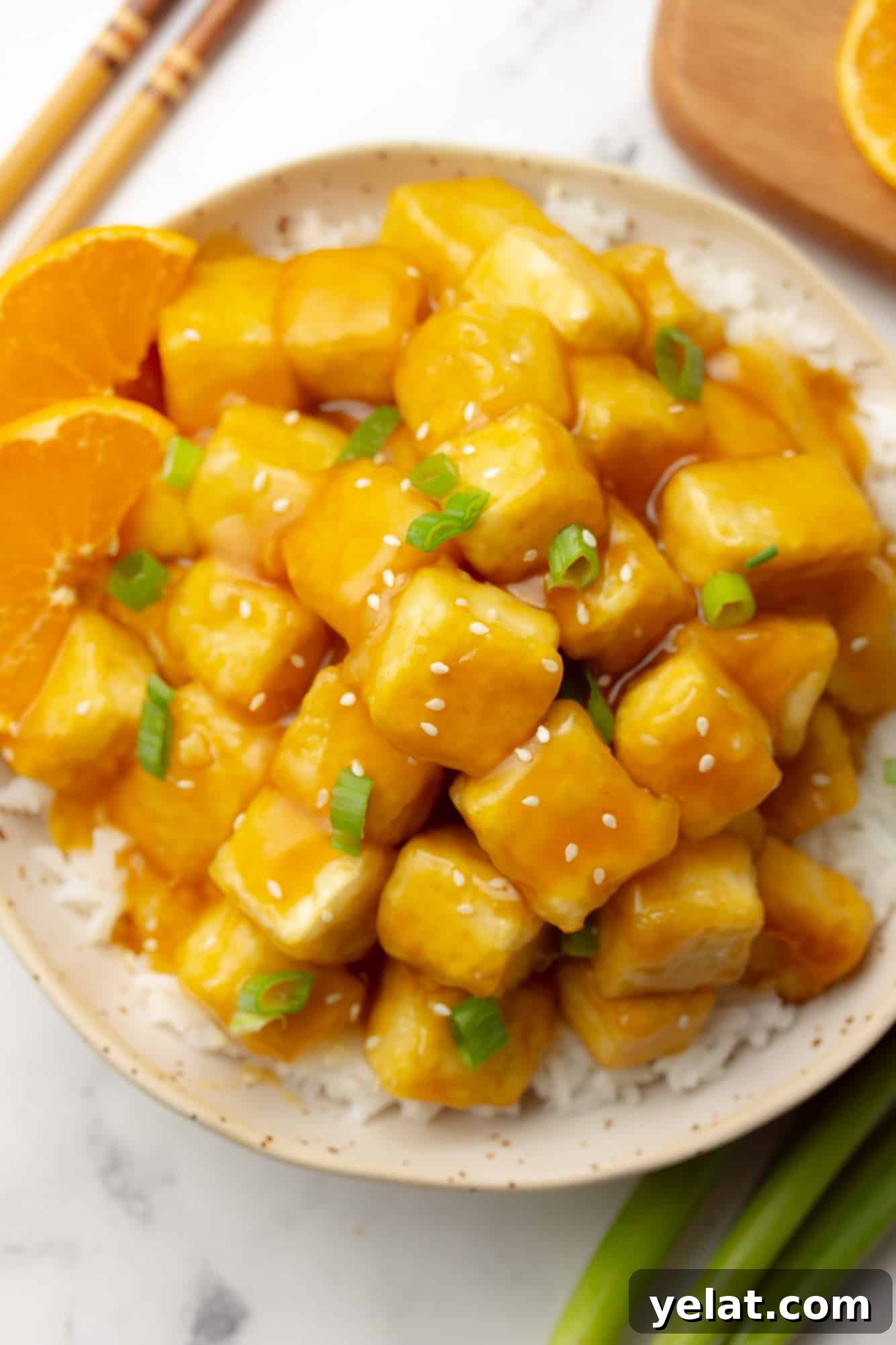 vegan orange tofu served over white rice in a bowl.