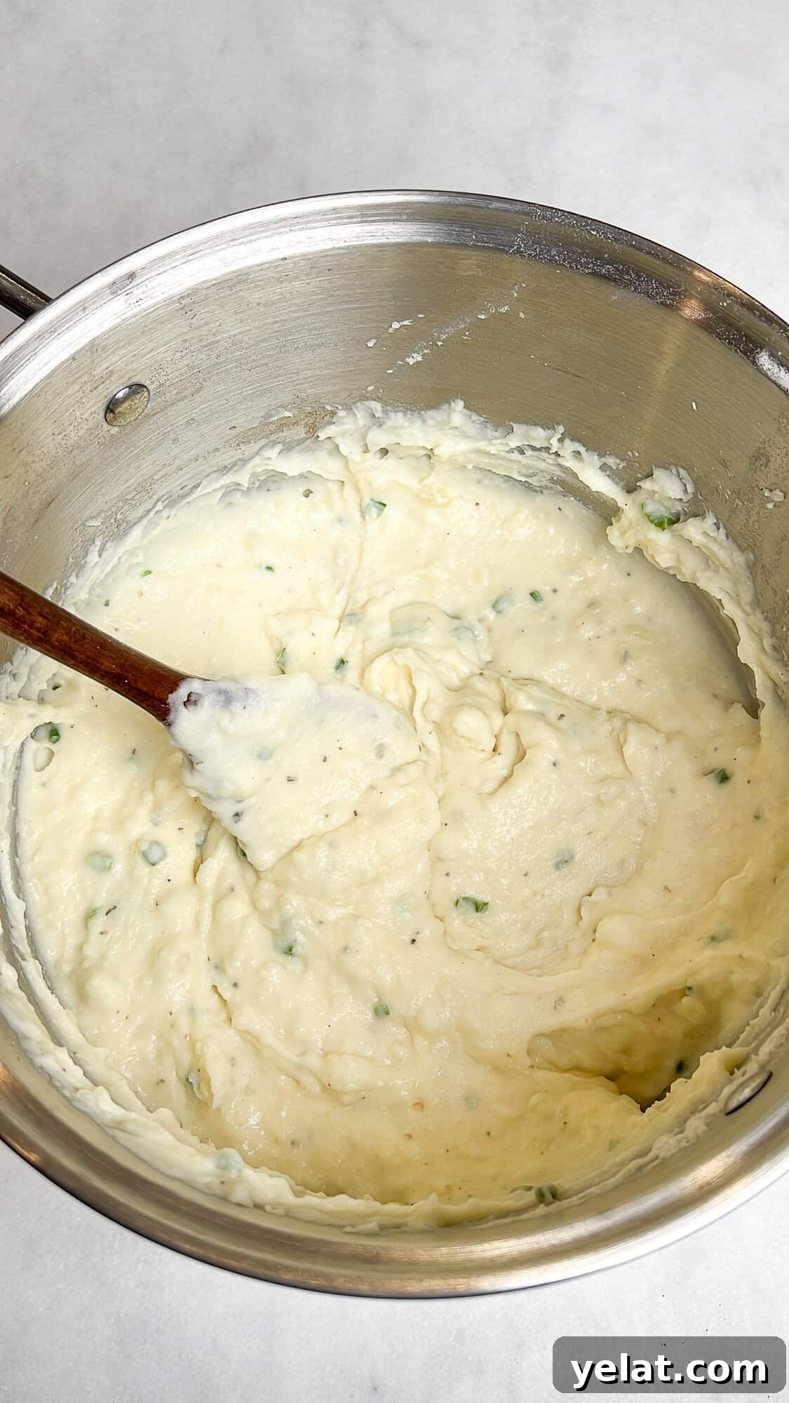 Boursin mashed potatoes in a pot with a wooden spoon