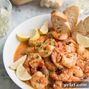 Tomato Shrimp Scampi Recipe: Garlic Butter Pasta with Fresh Tomatoes 7 Tomato Shrimp Scampi in a white bowl served with slices of toasted bread.