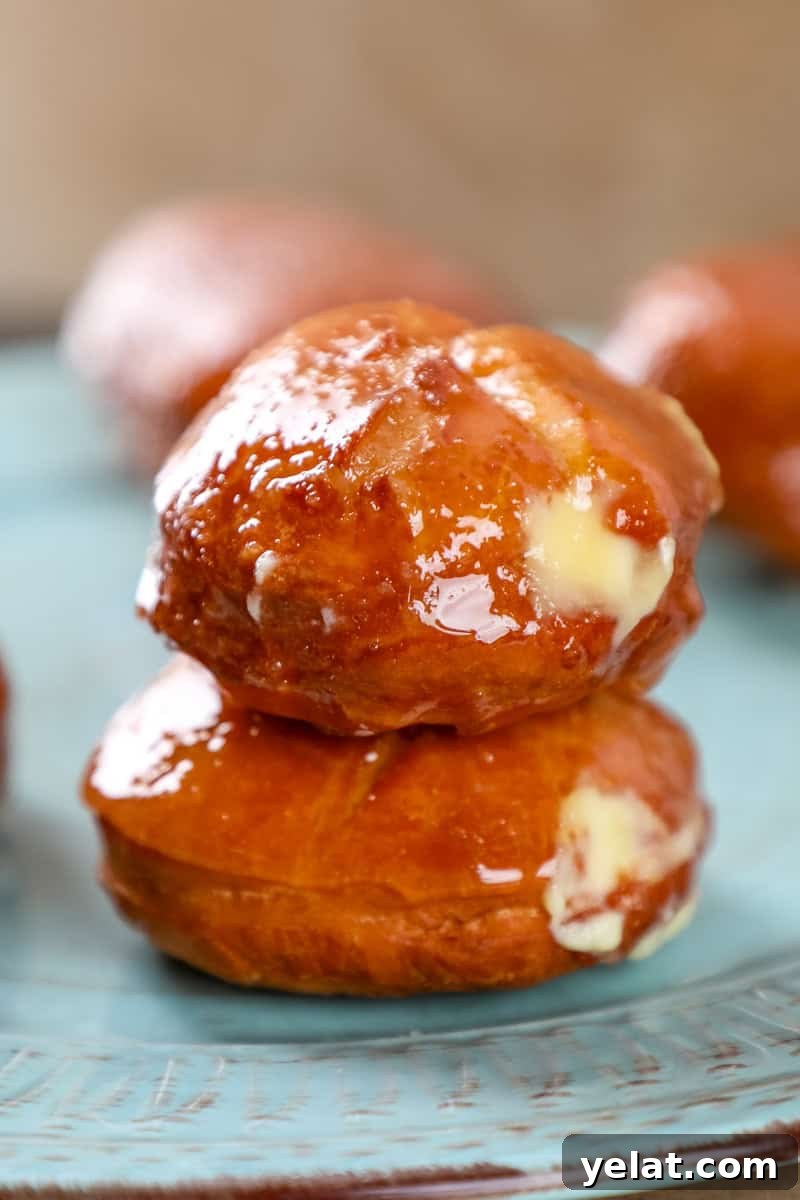Crème Brûlée–Filled Donuts: Decadent Custard-Stuffed Doughnuts 2 two creme brulee donuts on top of each other filled with vanilla custard and topped with a crispy caramel shell.