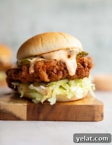 Fried Chicken Sandwich chicken sandwich on wooden board with sauce dripping out