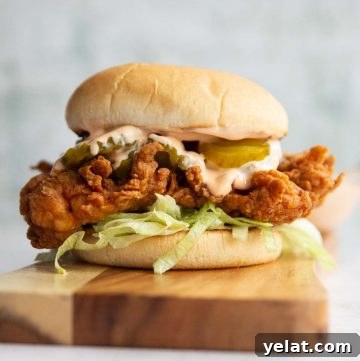 Classic Crispy Fried Chicken Sandwich Recipe for Homemade Success 2 chicken sandwich on wooden board with dip blurred in background