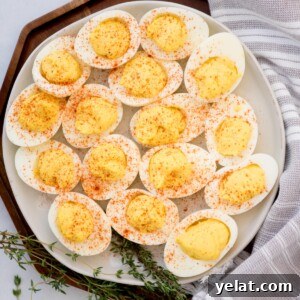 Creamy Deviled Eggs with Dijon Mustard and Fresh Herbs 10 Paprika sprinkled deviled eggs served on a white plate.