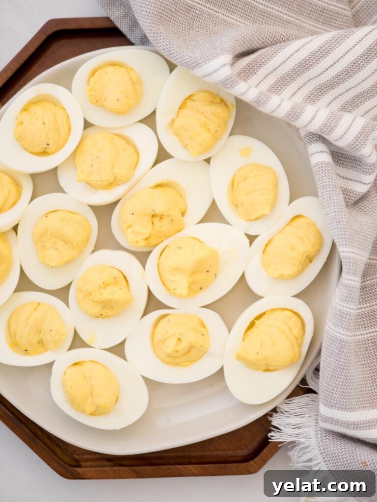 Creamy Deviled Eggs with Dijon Mustard and Fresh Herbs 8 Deviled eggs on a platter without paprika.