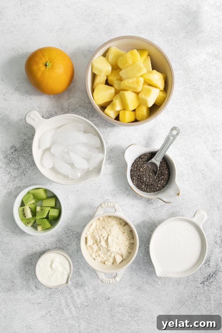 overhead photo of ingredients for this pineapple orange smoothie recipe arranged in white bowls on a light background