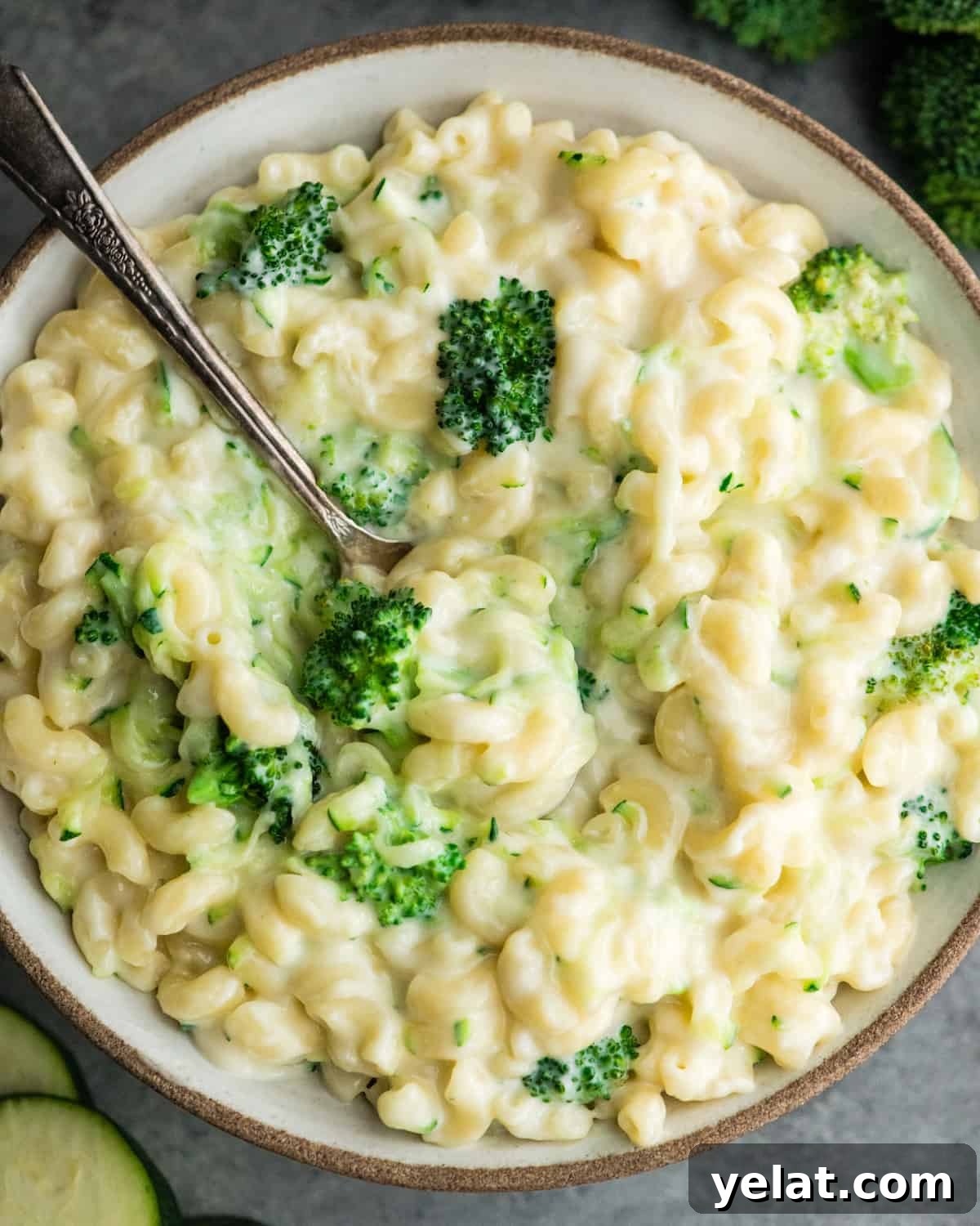overhead view of a bowl of vegetable mac and cheese with a spoon in it